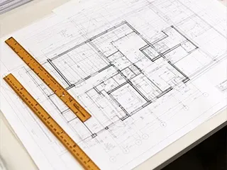 Planta arquitetônica com réguas sobre a mesa